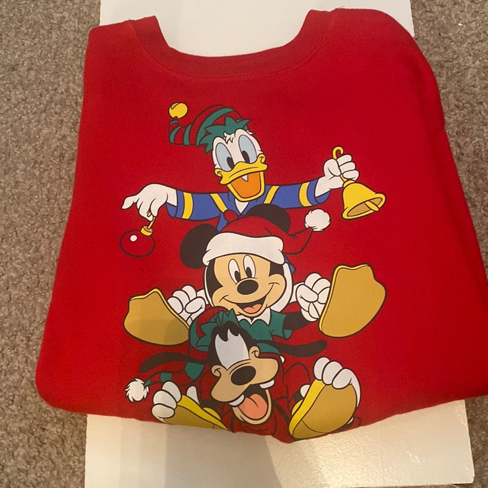 It’s a Christmas sweater with Mikey, goofy, and Donald on it, It’s a red sweater